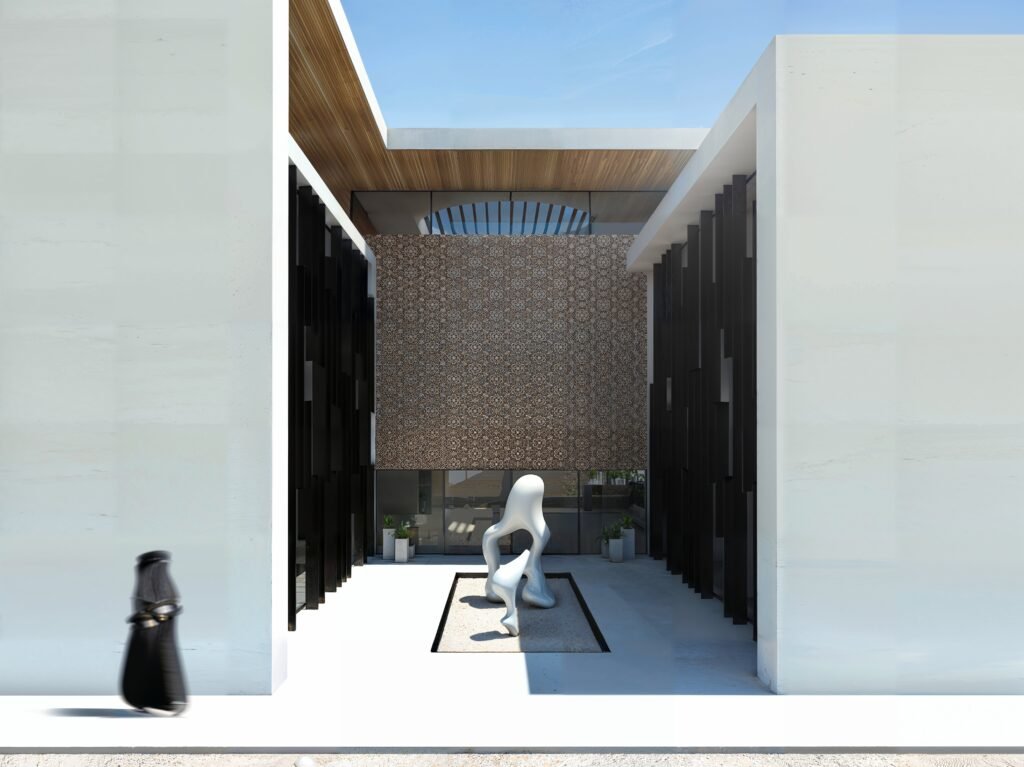 INJ Architects rendering of a semi enclosed courtyard entry with a white abstract sculpture on a dark plinth a geometric patterned wall in the background dark vertical fin screens a wooden slatted ceiling and a female figure in black walking in the foreground