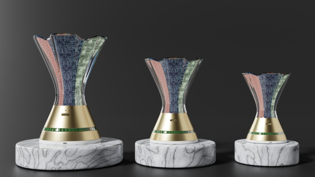 INJ Architects three flared ceremonial trophies of varying sizes resting on circular marble pedestals featuring golden bases green tiled bands and patterned transparent upper sections