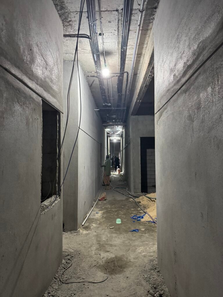Interior masonry corridor during cement plastering and wall preparation works