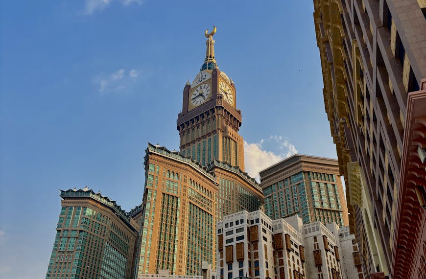 Stunning view of the Abraj Al Bait Towers in Mecca under a clear blue sky.