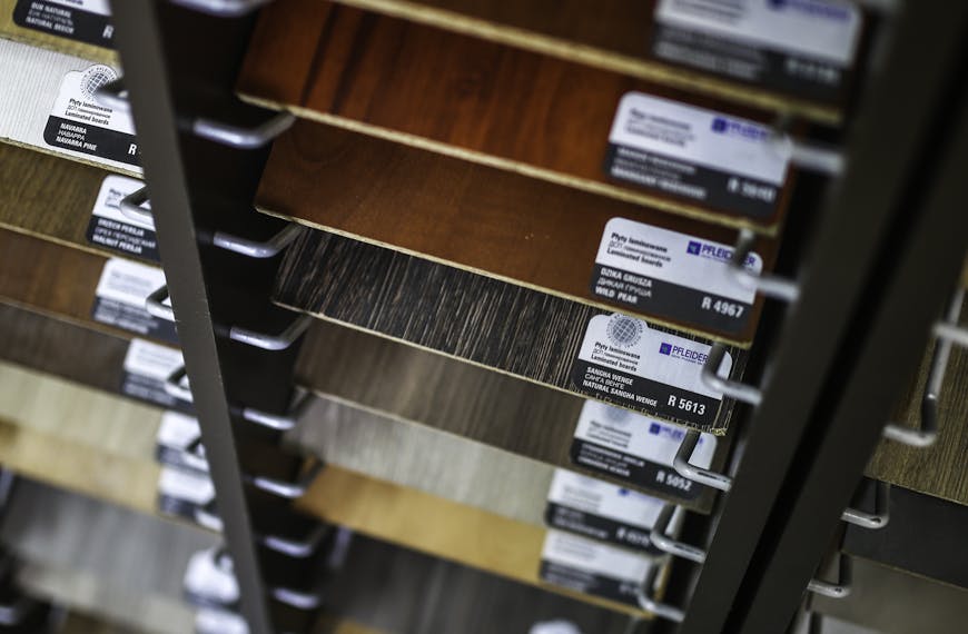 A collection of laminated wood samples organized in a vertical display rack for selection.