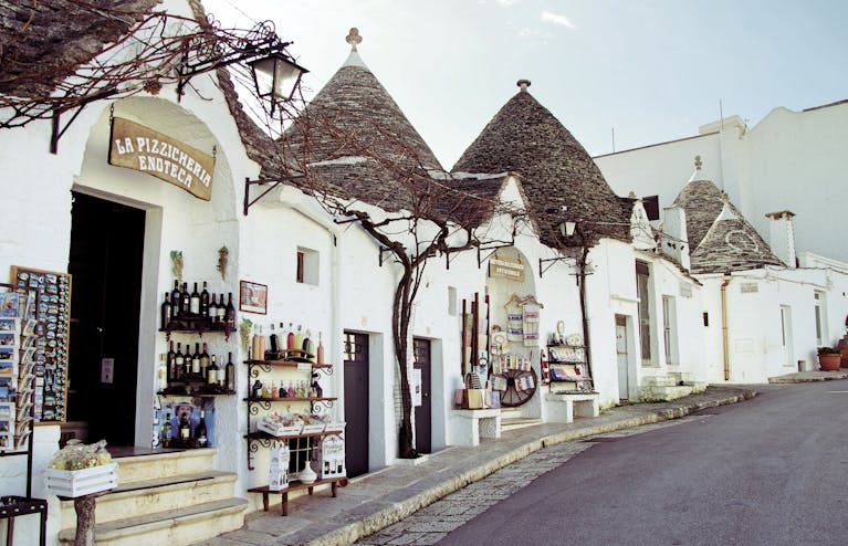 Charming street view of traditional Trulli houses showcasing local goods.