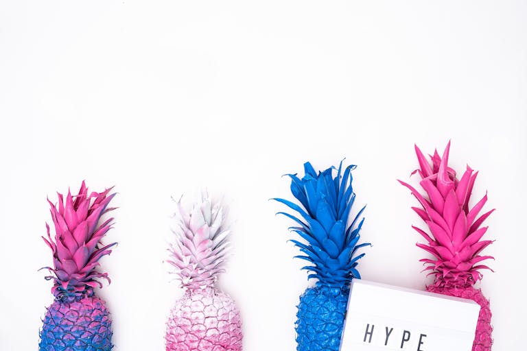 Colorful painted pineapples against a white backdrop for modern decor.