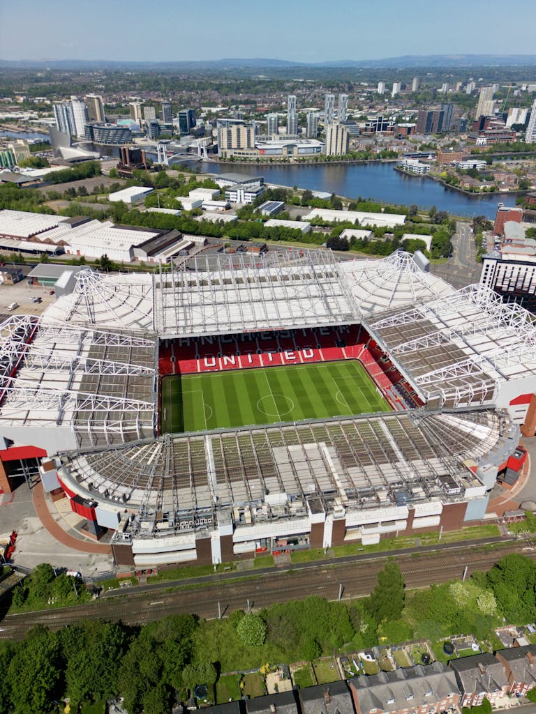 Stunning aerial view of Old Trafford Stadium in Manchester, showcasing its modern architecture and bustling cityscape.