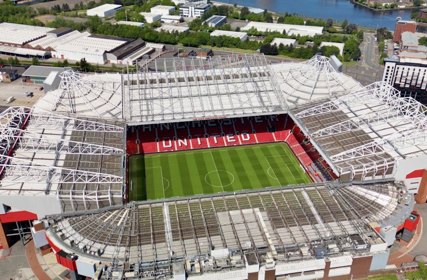 Stunning aerial view of Old Trafford Stadium in Manchester, showcasing its modern architecture and bustling cityscape.