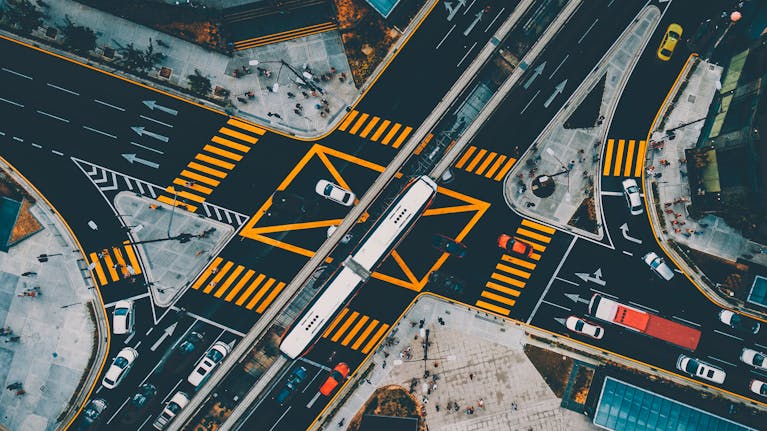 Dynamic aerial shot capturing a busy urban intersection in Kuala Lumpur with vibrant traffic and pedestrians.