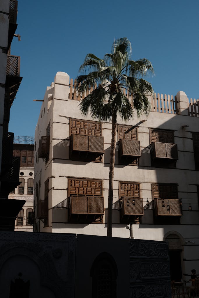 A picturesque view of historic architecture and a palm tree in Jeddah, Saudi Arabia.