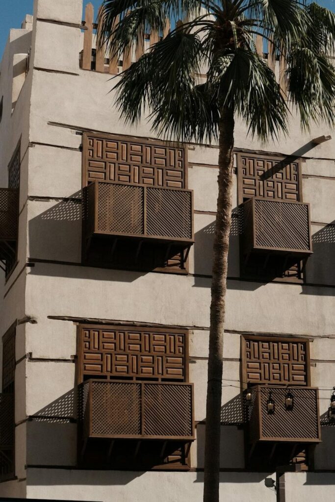 A picturesque view of historic architecture and a palm tree in Jeddah, Saudi Arabia.