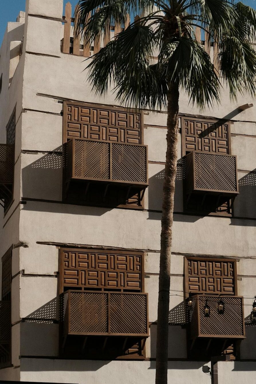 A picturesque view of historic architecture and a palm tree in Jeddah, Saudi Arabia.