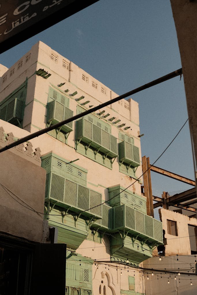 Historic building with green lattice balconies in Jeddah's old town.