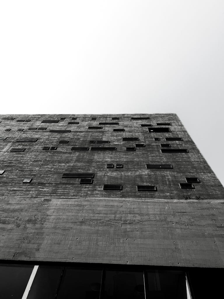 Low-angle shot of a modern concrete building facade in black and white.