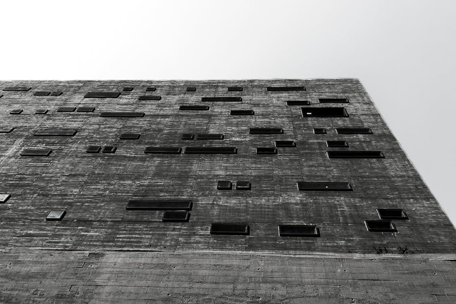 Low-angle shot of a modern concrete building facade in black and white.
