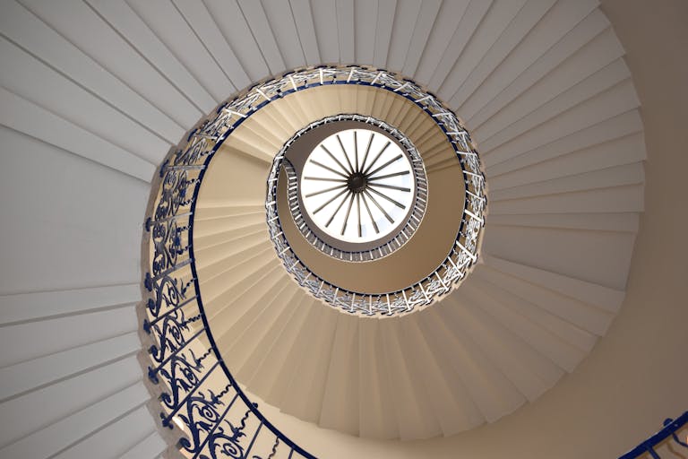 A captivating view up a spiral staircase with intricate railing design.