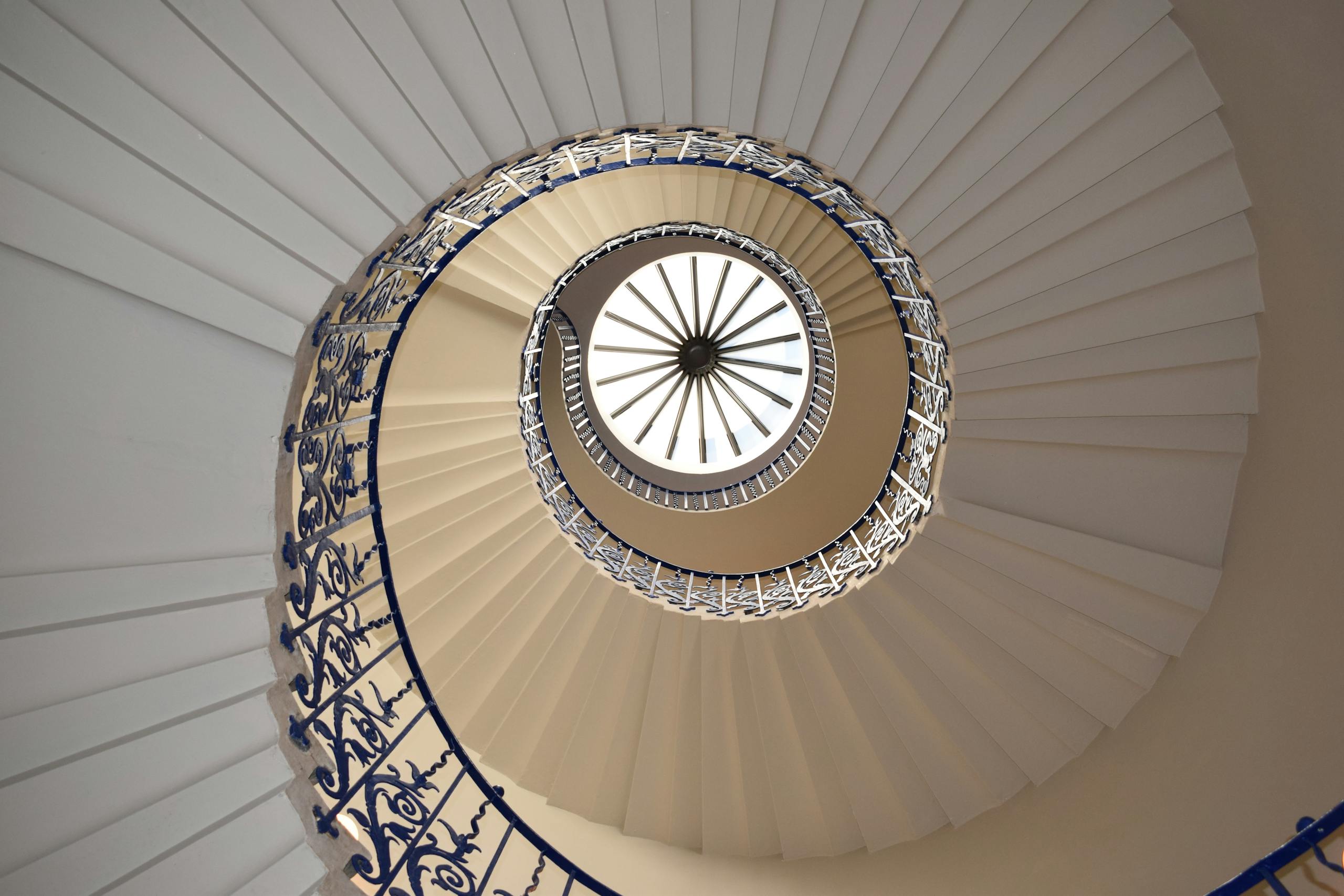 A captivating view up a spiral staircase with intricate railing design.