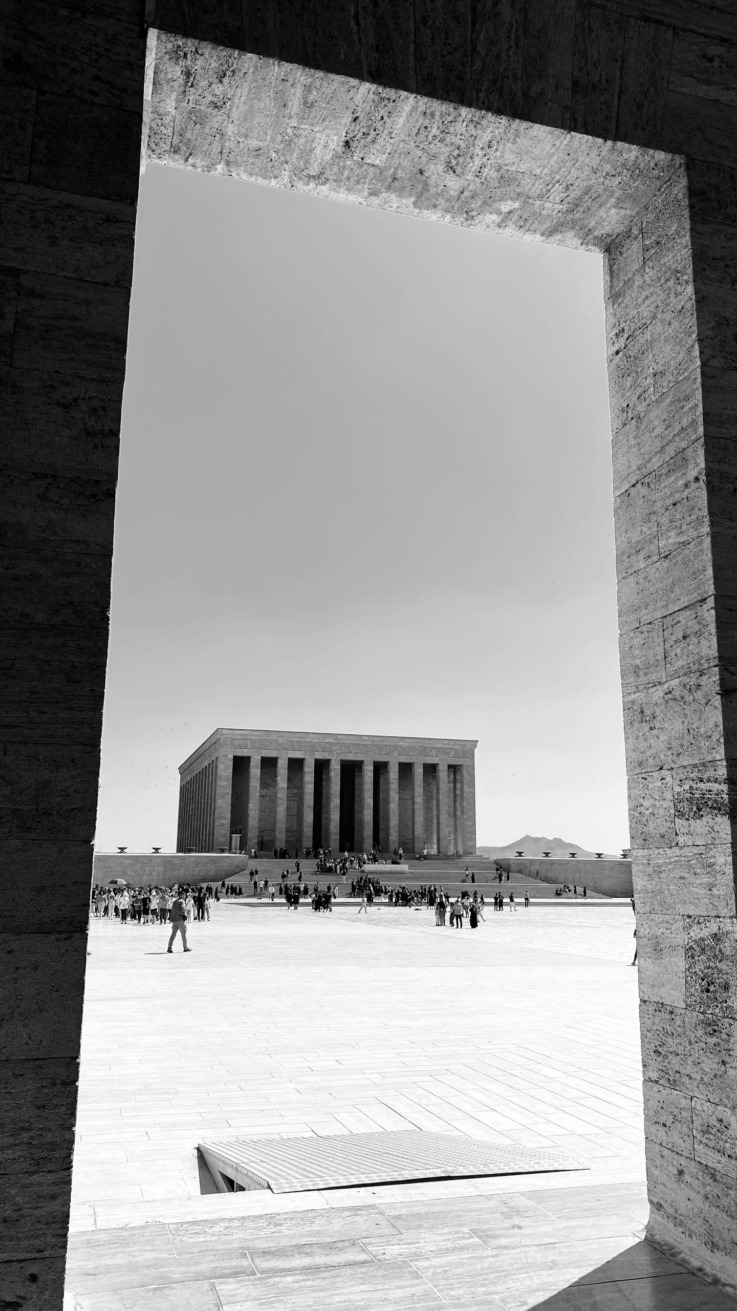 A striking black and white view of Anıtkabir with visitors on a sunny day in Ankara, Türkiye.
