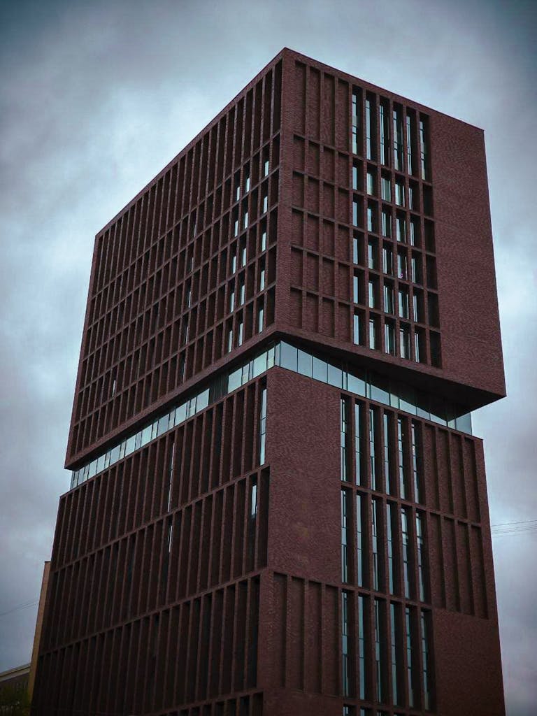 Dynamic architecture shot of a contemporary building under a moody sky, showcasing modern design.