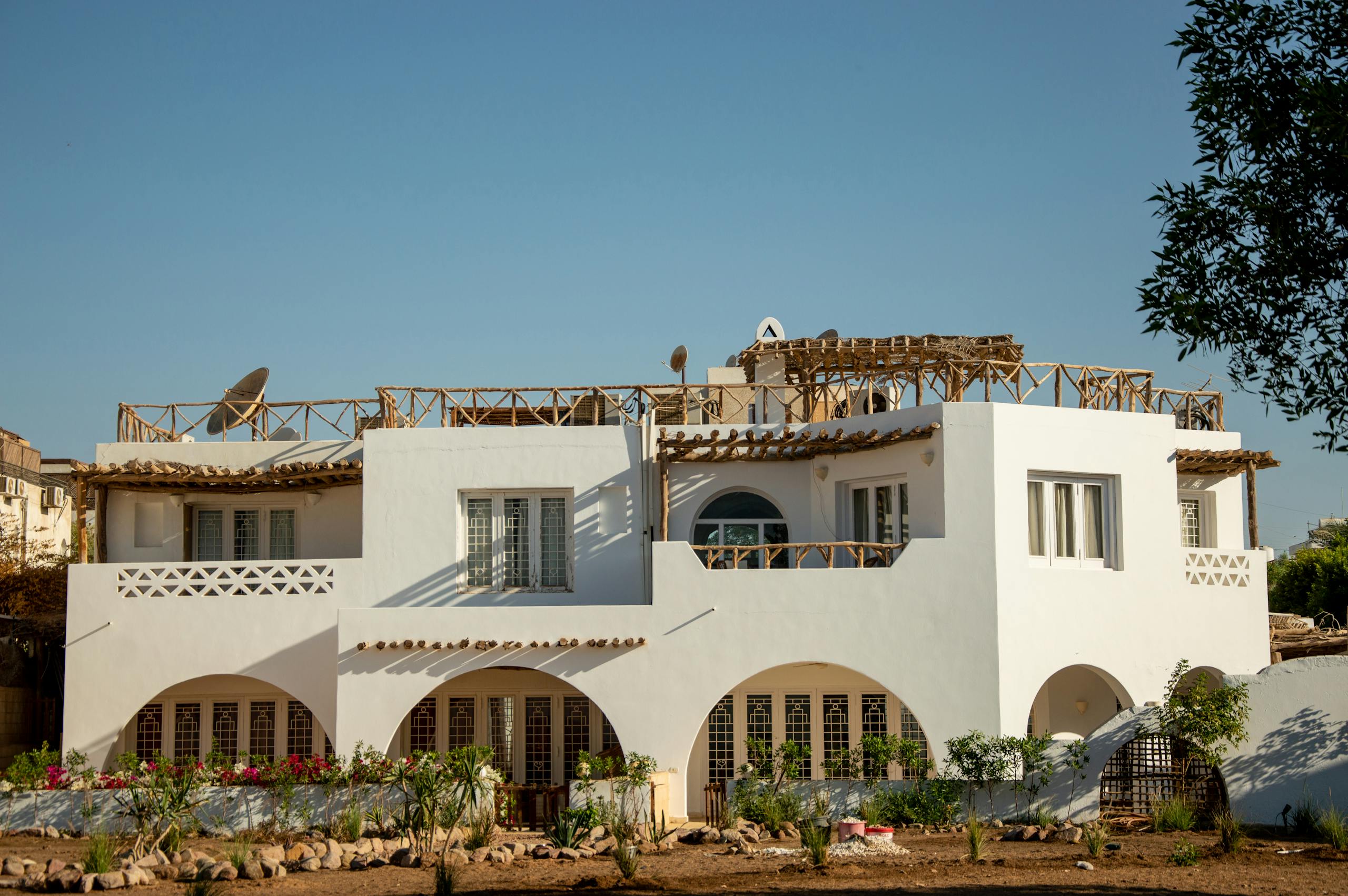 Elegant white villa in a sunlit desert setting, perfect for vacation or residential use.