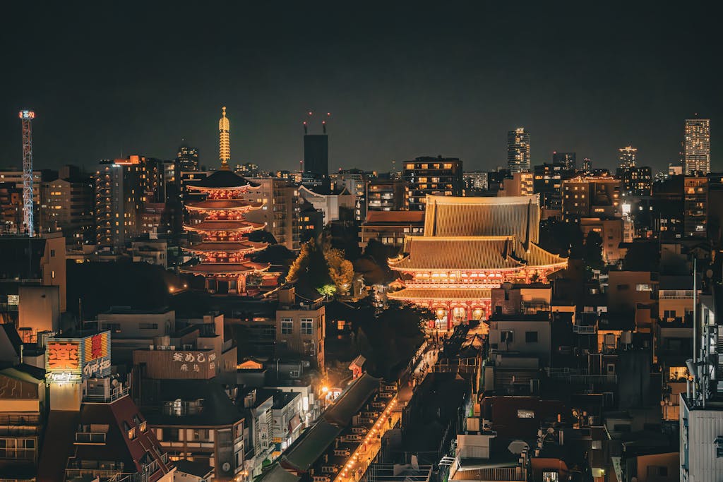 Stunning nighttime aerial view of Senso-ji Temple and Tokyo skyline in Taito City, Japan.