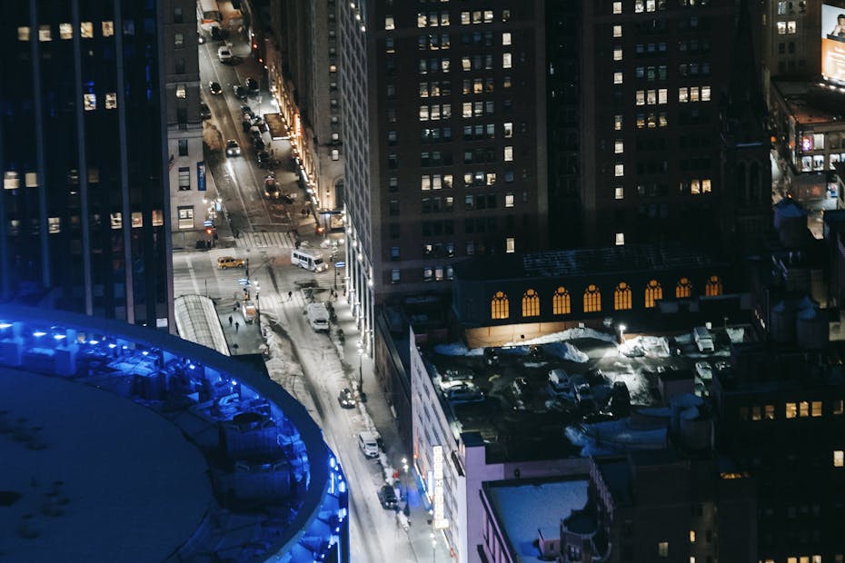 Stunning aerial view of a lively urban cityscape at night with illuminated skyscrapers and streets.