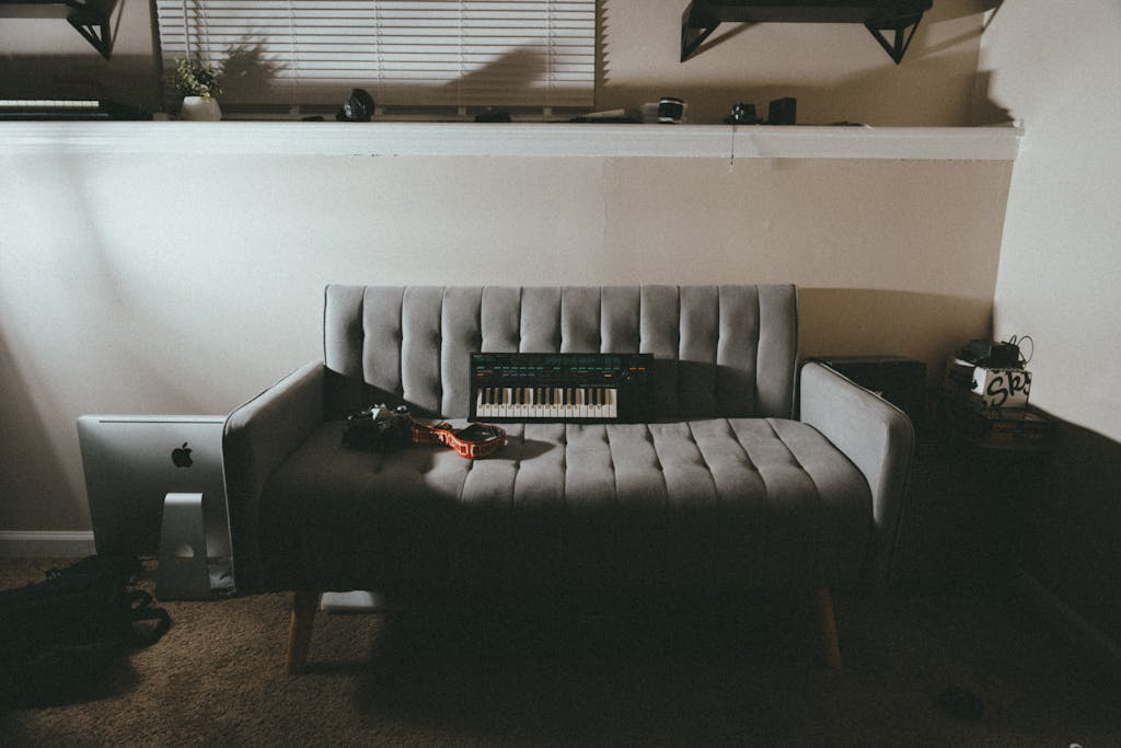 Stylish living room featuring a grey sofa and electronic keyboard, embodying modern interior design.