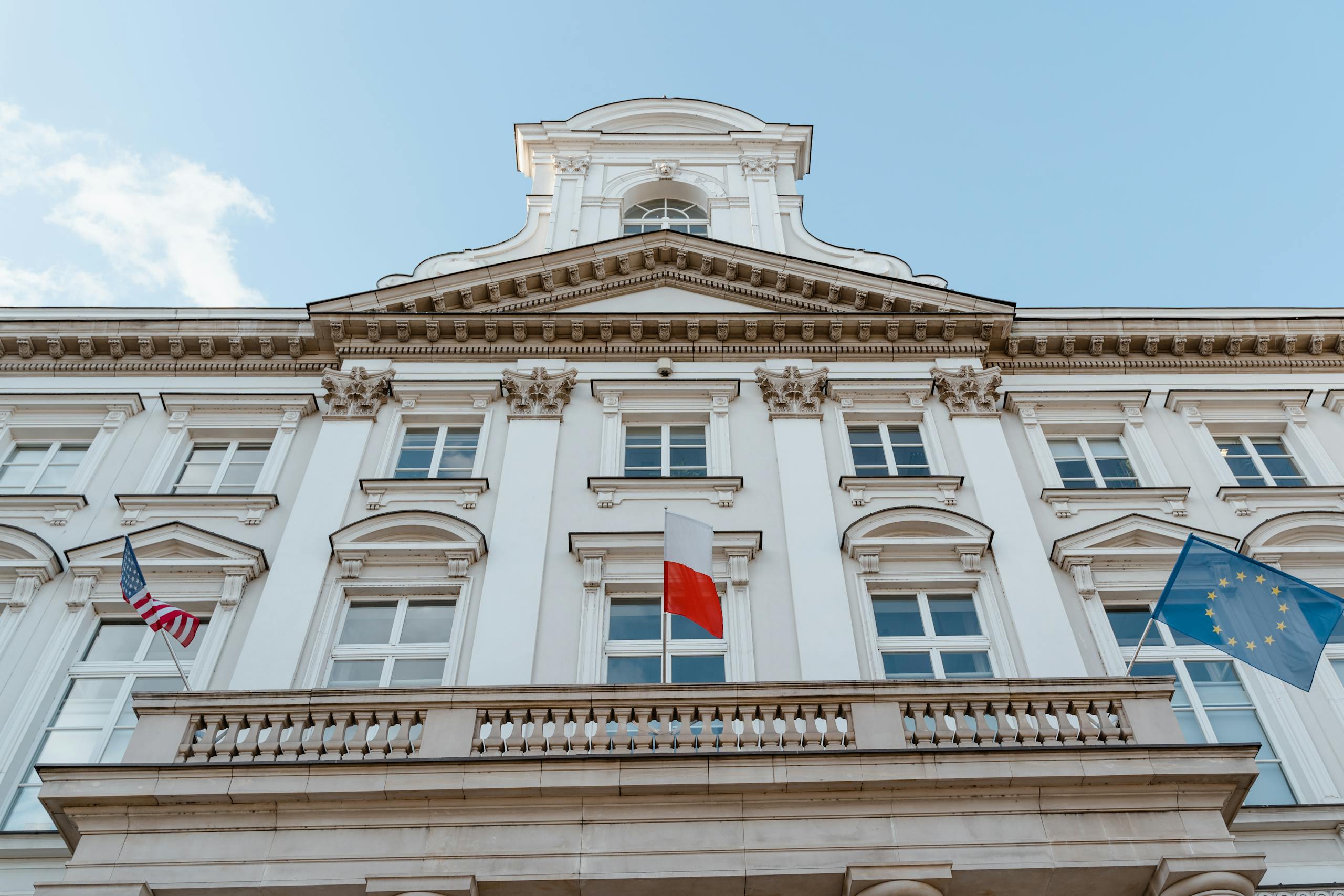 A classic architectural facade with multiple flags, showcasing international representation.