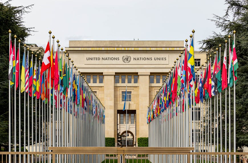 View of the United Nations Office in Geneva adorned with flags of various countries.