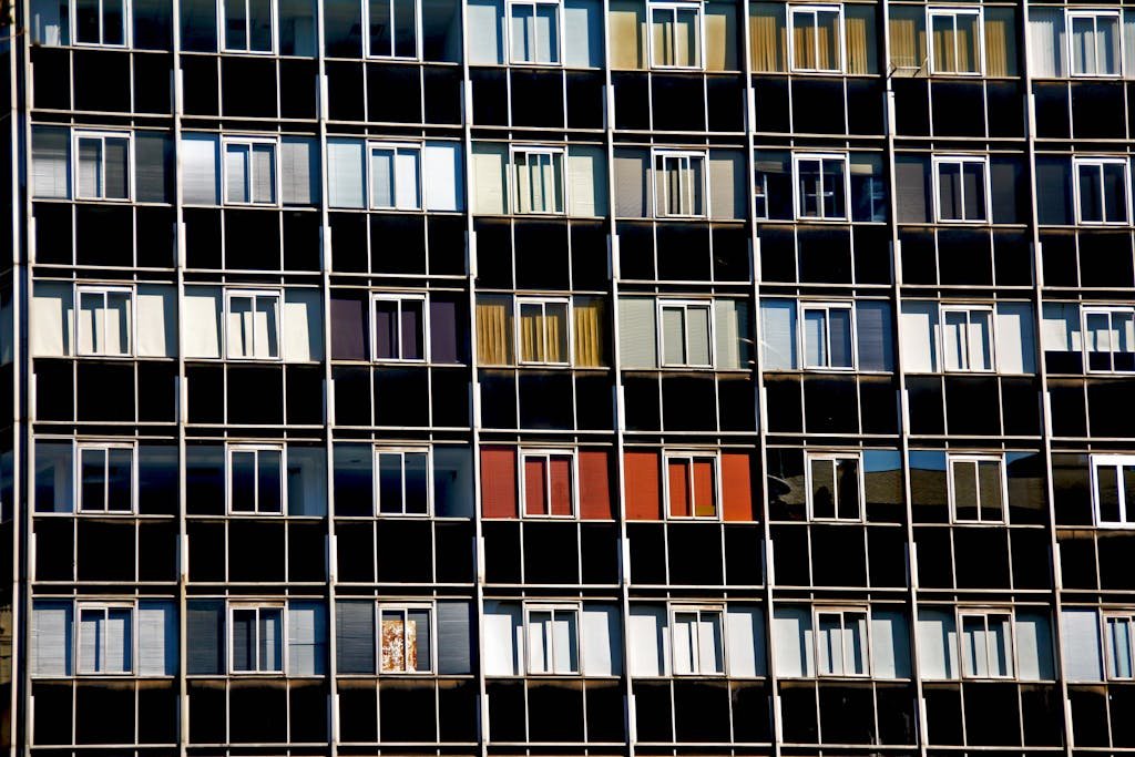 A vibrant facade of a modern apartment building with varied window colors and patterns.