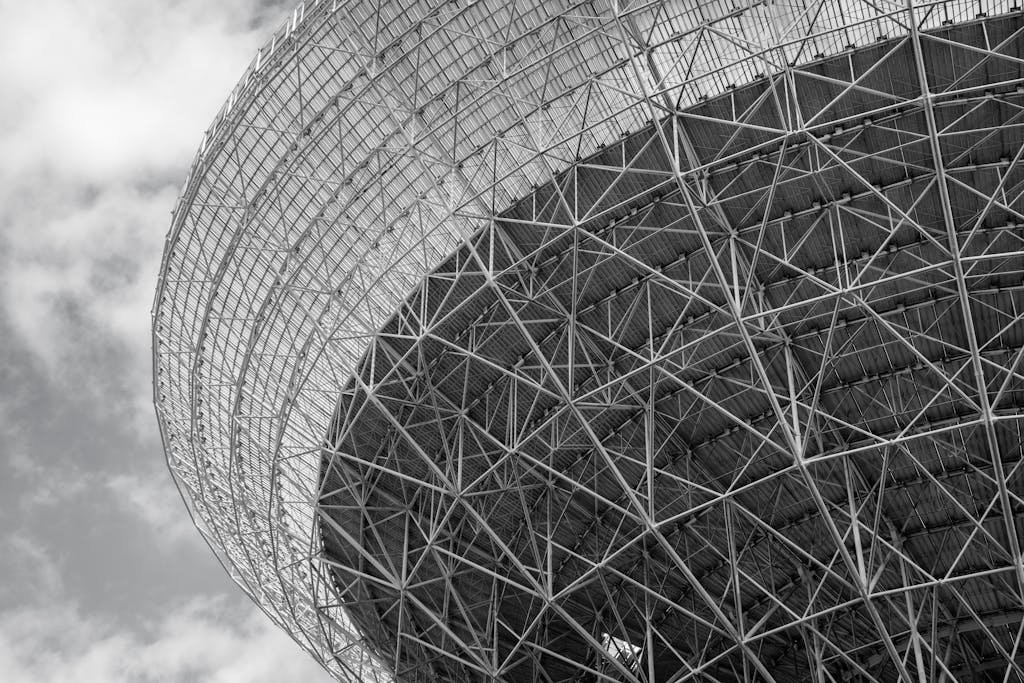Geometric black and white photo of a futuristic steel structure, showcasing modern architectural design and patterns.