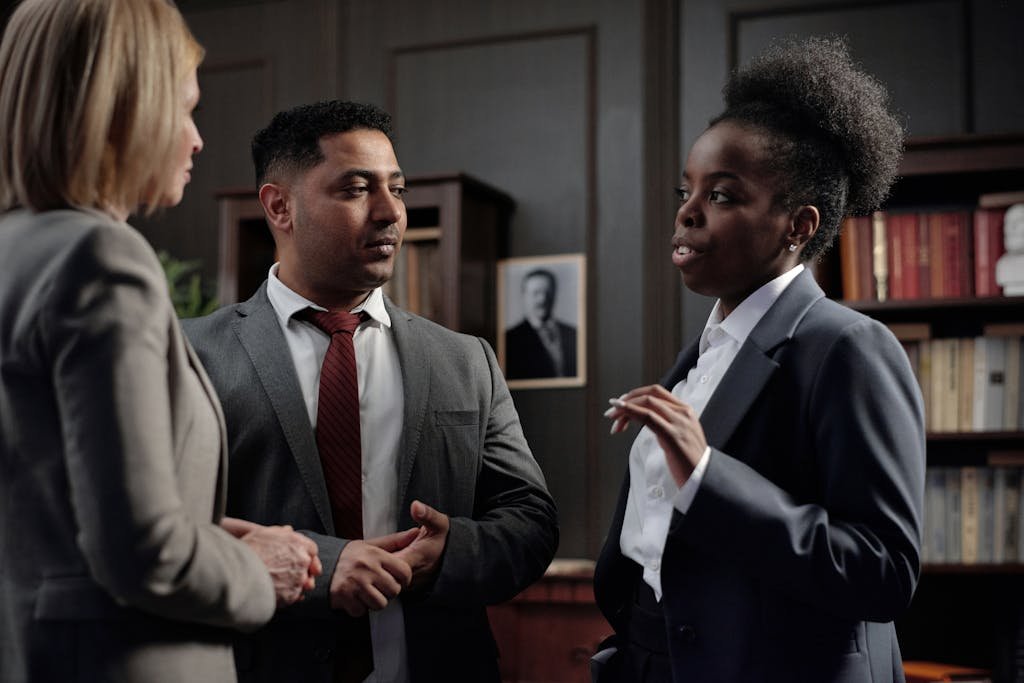 Group of diverse professionals discussing in office setting, highlighting teamwork and collaboration.