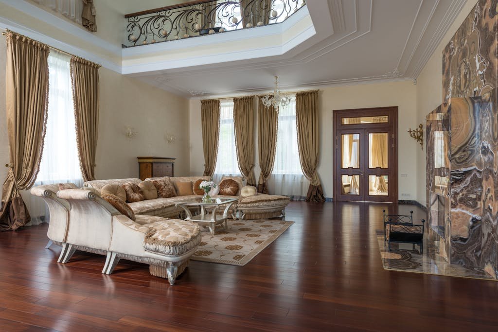 Large comfortable living room decorated with long curtains and rug on brown laminate