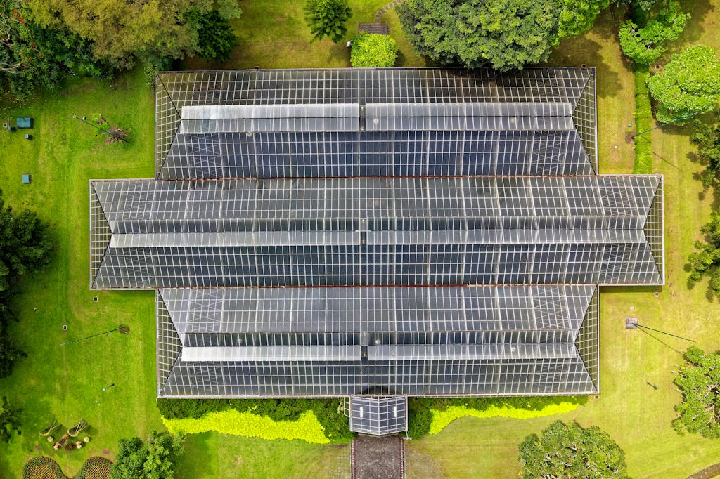 Top-down view of a modern greenhouse surrounded by lush greenery in Indonesia.