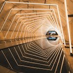 Explore a modern tunnel with geometric LED light patterns reflecting on the water.