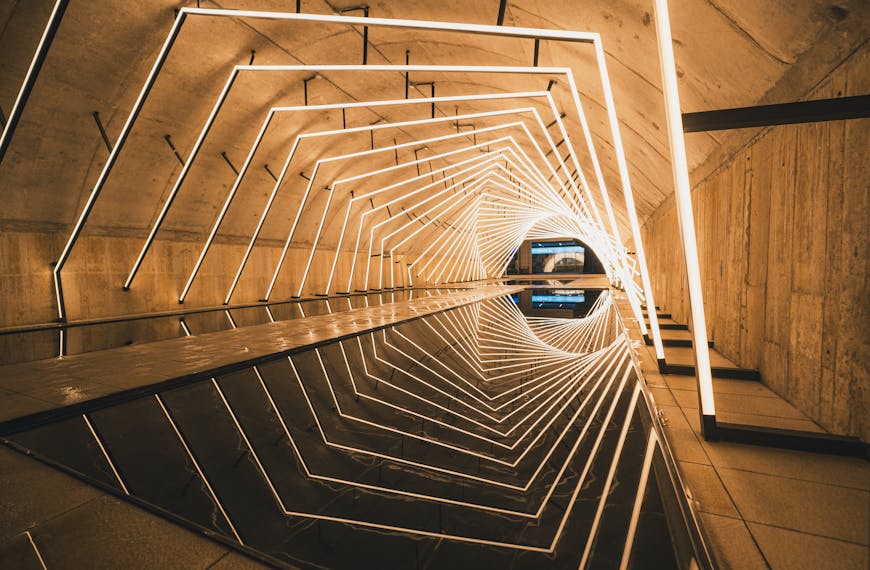 Explore a modern tunnel with geometric LED light patterns reflecting on the water.