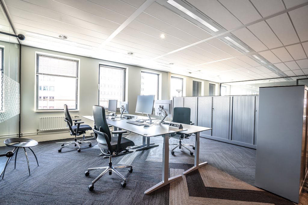 Bright and spacious modern office interior featuring sleek workstations and ergonomic chairs.