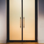 Elegant frosted glass doors with golden handles, perfect for contemporary interior design.