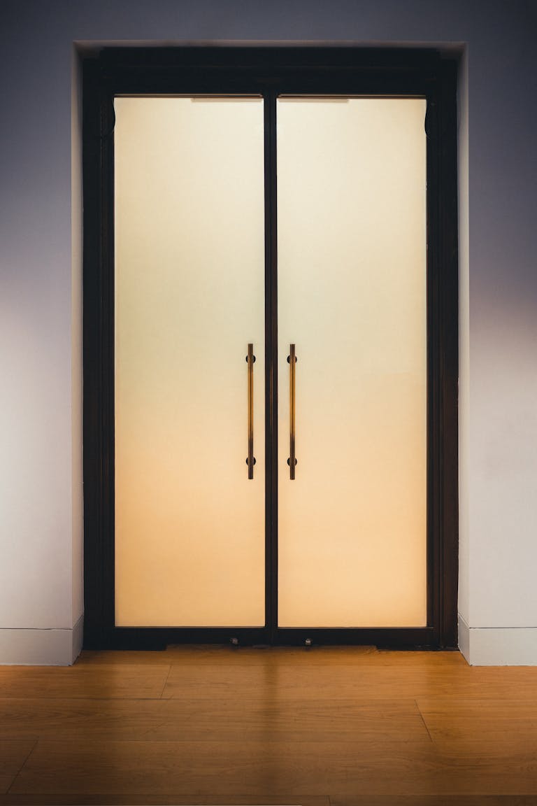 Elegant frosted glass doors with golden handles, perfect for contemporary interior design.