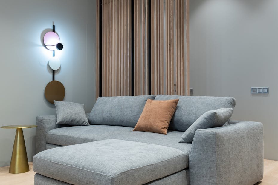 Interior of modern living room with sofa with pillows next to round table under conditioner