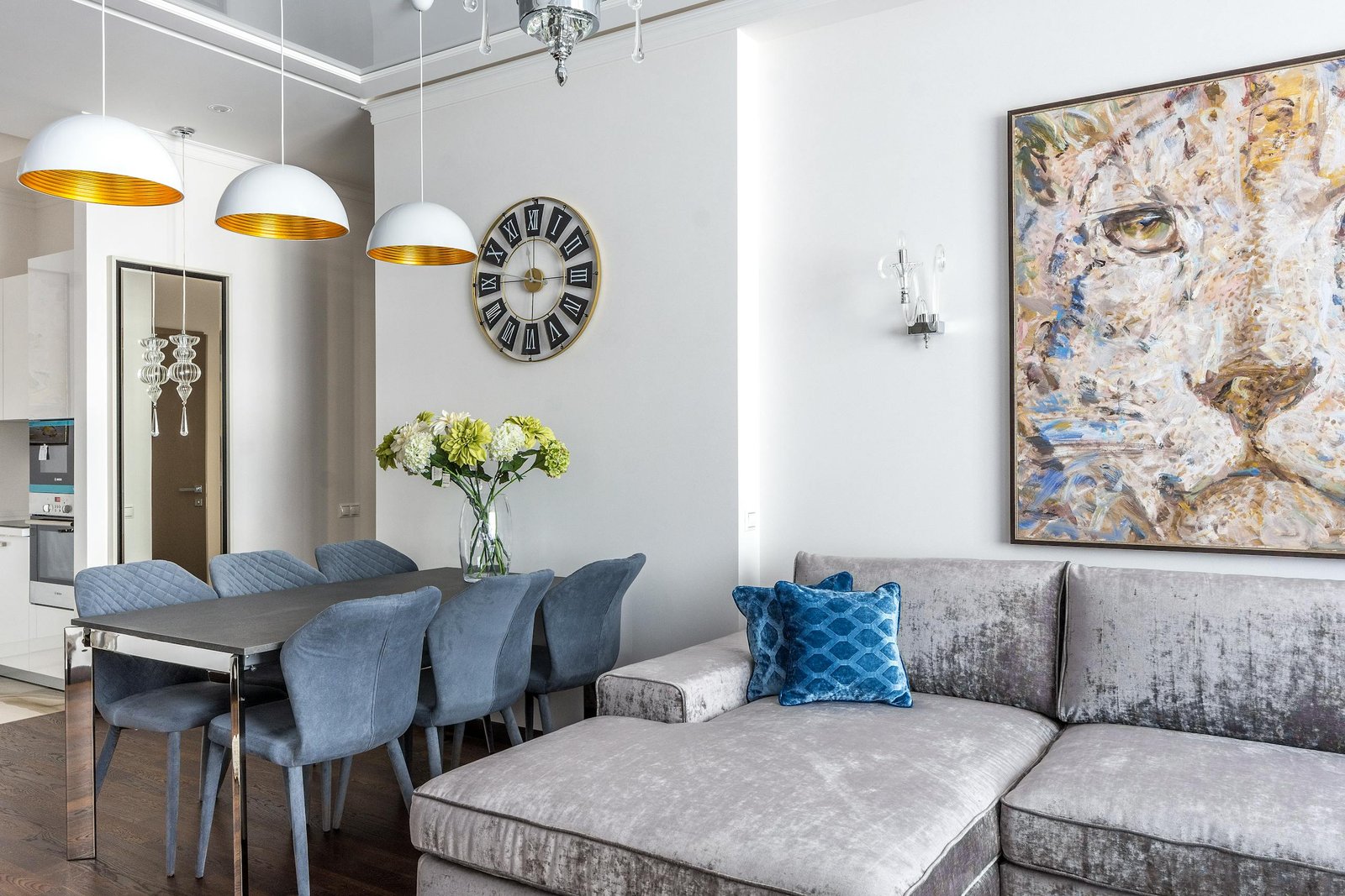 Interior design of cozy living room with comfortable sofa with cushions and table with flowers in vase in studio