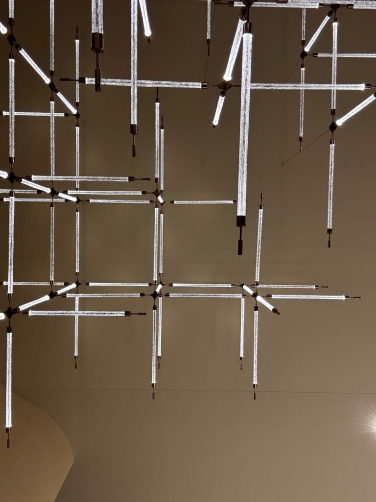 Orthographic ceiling documentation of a residential project featuring a custom modular geometric lighting matrix composed of illuminated textured glass rods and black metallic joints against a neutral matte soffit.