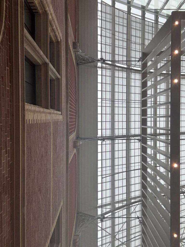 Orthographic ceiling documentation of the Rijksmuseum courtyard in Amsterdam, displaying the critical link between the 19th-century red brick facade and a vast modern glass and steel grid skylight.