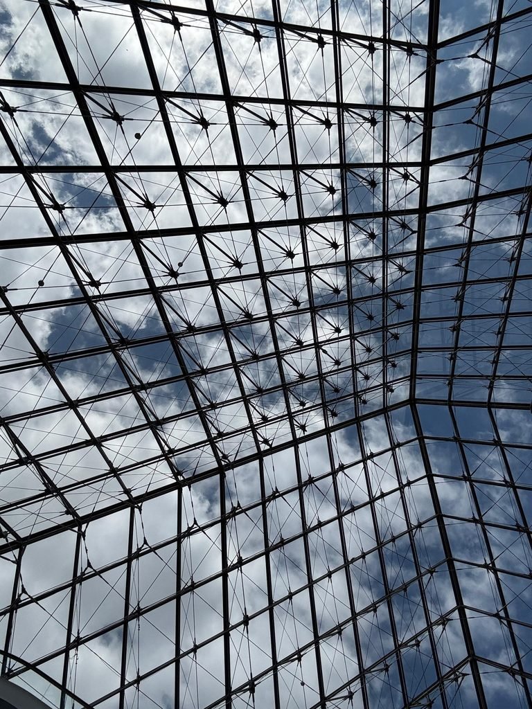Ceilography — Case 090. Musée du Louvre Glass Pyramid, Paris, France (2026). Orthographic documentation of I.M. Pei's iconic glass pyramid ceiling featuring structural steel spider fittings, webbed tension-rod cable trusses, and diamond-patterned glazing, as part of the Ceilography architectural research archive.